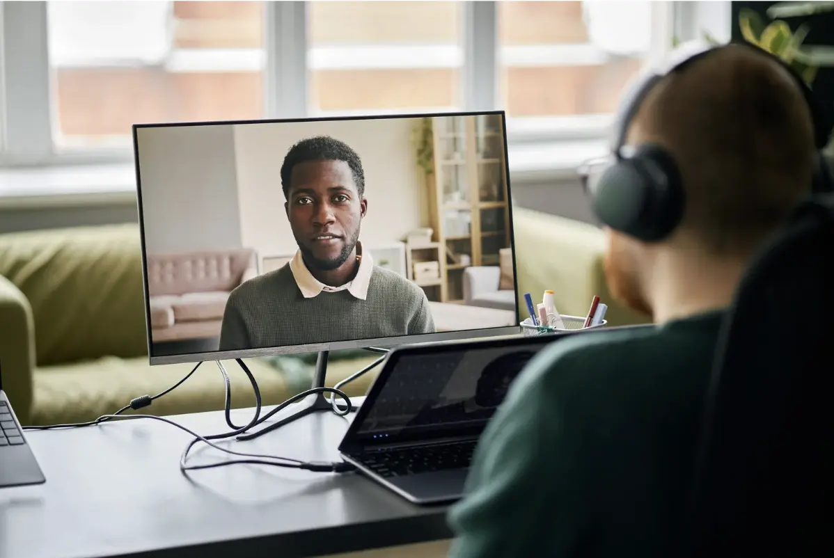 A 1 on 1 online coaching session with desktop computer and two men.